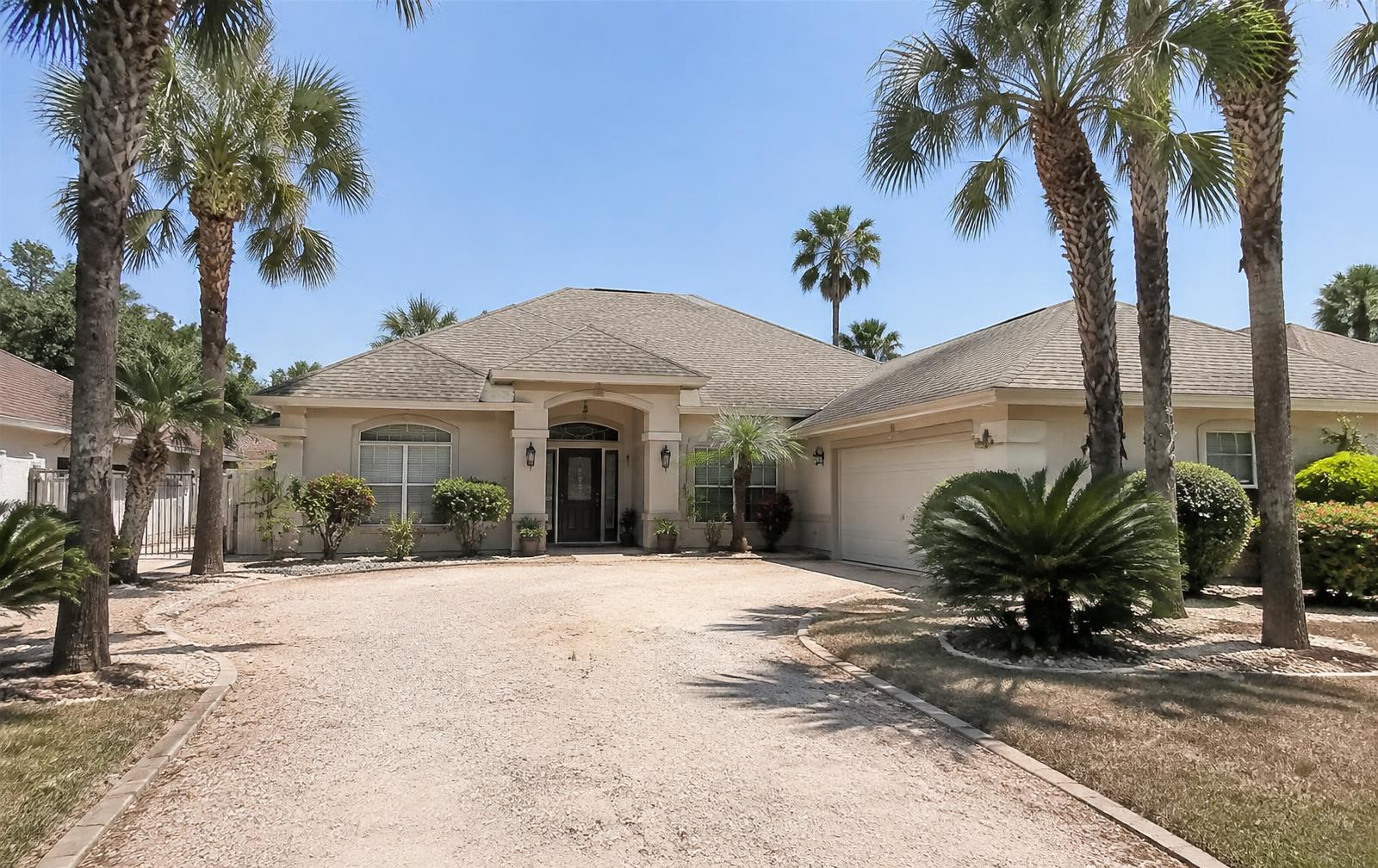 Stucco hip-roof home with palm trees in the Rio Grande Valley